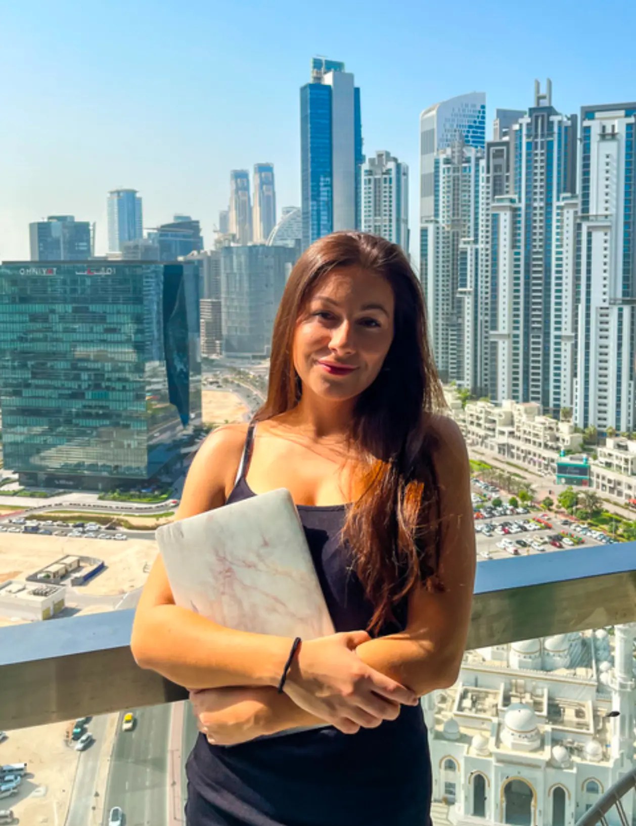 Kristína s notebookom pred panorámou Dubaja – práca virtuálnej asistentky odkiaľkoľvek